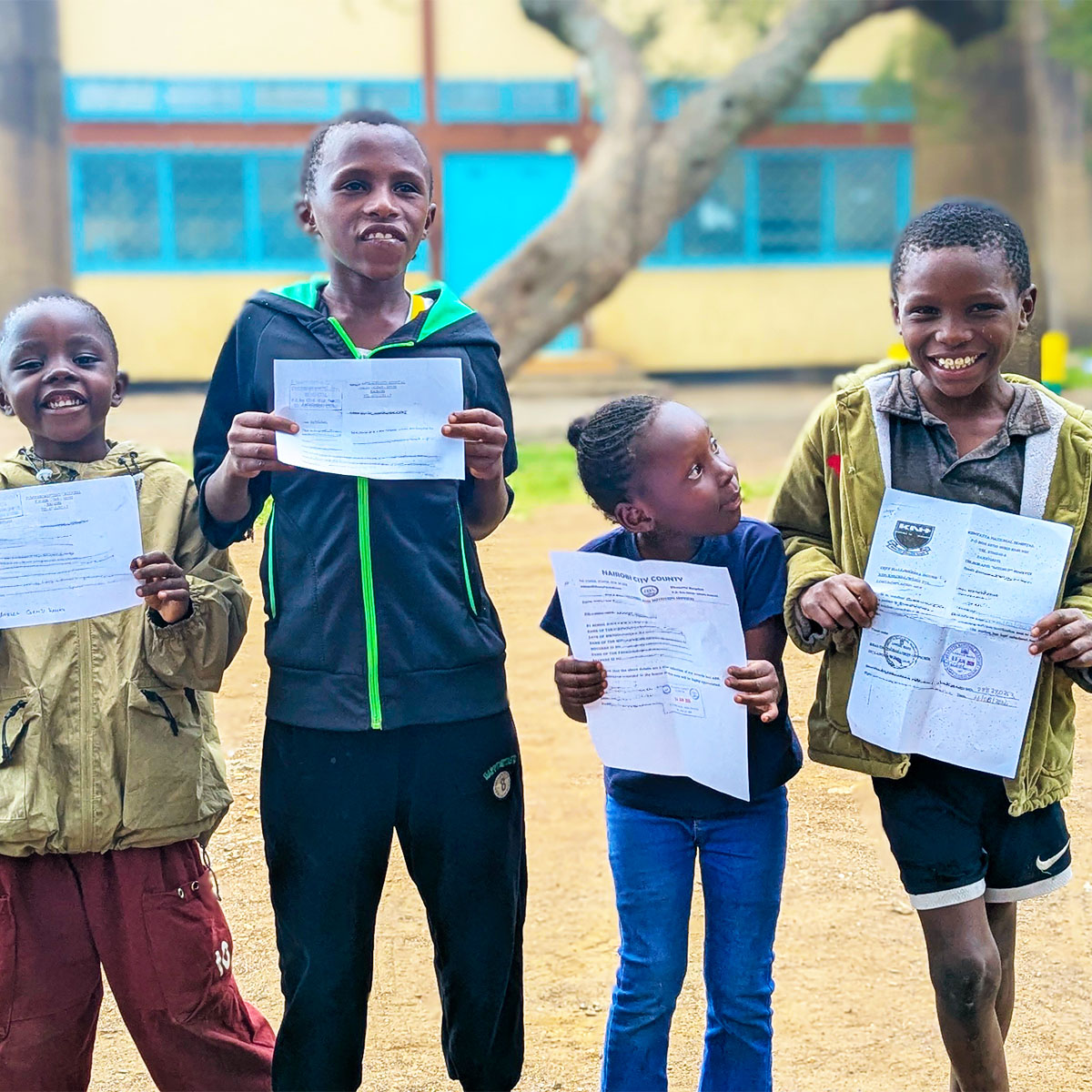 Children from Maria's community holding their birth certificates